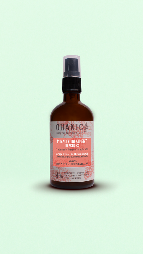 Bild einer 250 ml Flasche von Ohanic Miracle Treatment 10 Actions Leave-In. Die braune Flasche hat einen schwarzen Pumpspender und ein Etikett in rosa und weiß. Das Produkt enthält Traubenextrakt und Abyssinian-Öl, ist vegan und besteht zu 100% aus natürlichen Ursprungs-Extrakten. Es ist frei von Sulfaten, Silikonen, Farbstoffen, PEG-S, Salz und Gluten. Auf dem Etikett steht 'Miracle Treatment 10 Actions', 'Leave-In Treatment', 'Grape Extract & Abyssinian Oil'
