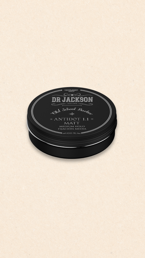 Bild eines 100 ml Behälters von Dr. Jackson Old School Barber Antidot 1.1 Matt Pomade. Der schwarze Behälter hat ein klassisches Design mit Schraubdeckel und weißer Schrift. Die Pomade bietet mittleren Halt und ein mattes Finish. Auf dem Behälter steht in mehreren Sprachen 'Matt Medium Hold' und 'Fijación Media'