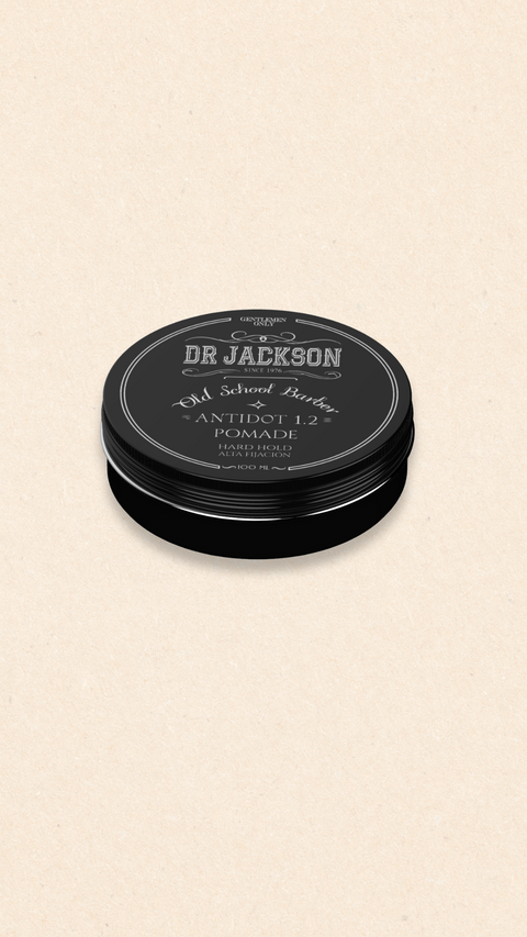 Bild eines 100 ml Behälters von Dr. Jackson Old School Barber Antidot 1.2 Pomade. Der schwarze Behälter hat ein klassisches Design mit Schraubdeckel und weißer Schrift. Die Pomade bietet starken Halt. Auf dem Behälter steht in mehreren Sprachen 'Pomade Hard Hold' und 'Pomada Alta Fijación'