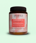 Bild eines 1000 ml Behälters von Ohanic Restore & Repair 3in1 Haarmaske. Der braune Behälter hat ein schwarzes Schraubverschluss-Design und ein Etikett in rosa und weiß. Die Haarmaske enthält Trauben- und Orangenblüten-Extrakte, ist cruelty-free und vegan, und besteht zu 100% aus natürlichen Ursprungs-Extrakten. Sie ist frei von Silikonen, Sulfaten, Gluten, Paraffinen, PEG-S, Salz und Farbstoffen. Auf dem Etikett steht 'Grape & Orange Flower Extracts' und 'Mascarilla 3en1 Reparadora / 3in1 Repair Mask